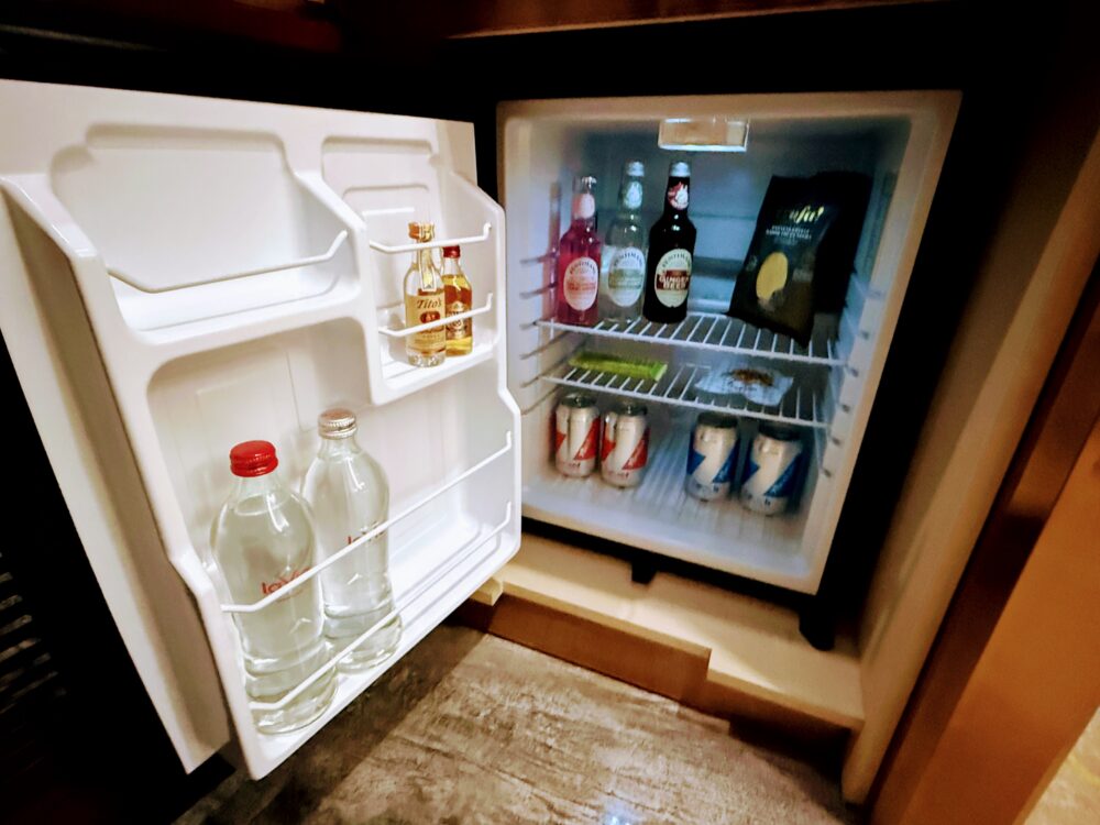客室の冷蔵庫内。有料のビール、炭酸飲料、ミネラルウォーター、チョコレート菓子が棚に並んでいる。