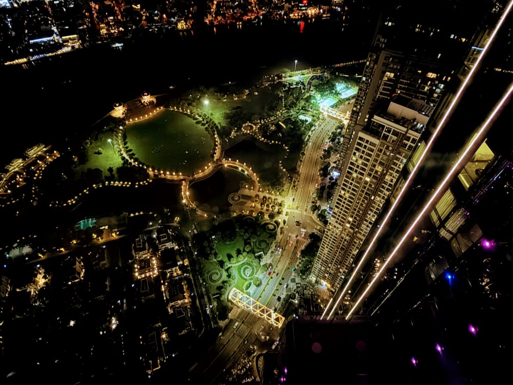 ヴィンパール ランドマーク81の客室から見下ろす夜景。ライトアップされた公園の遊歩道や、車のヘッドライトが流れる道路が鮮やかに輝いている。