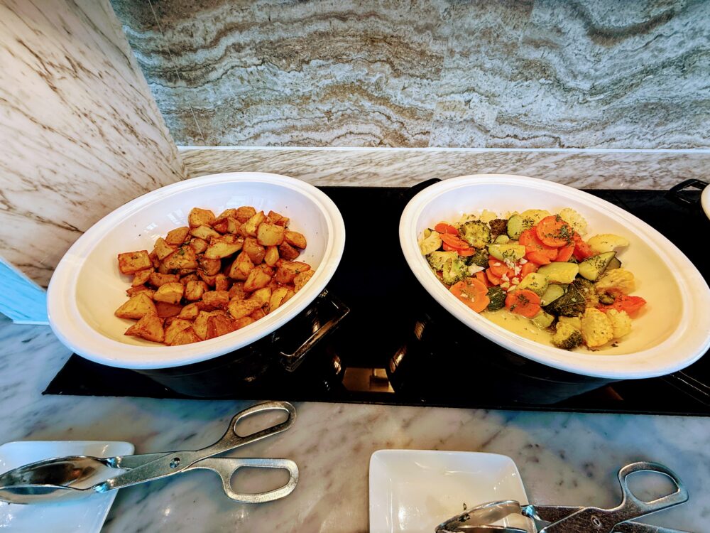 朝食ビュッフェのホットミールコーナー。ハーブで味付けされたローストポテトと、ブロッコリー、カリフラワー、人参などの温野菜ミックス。