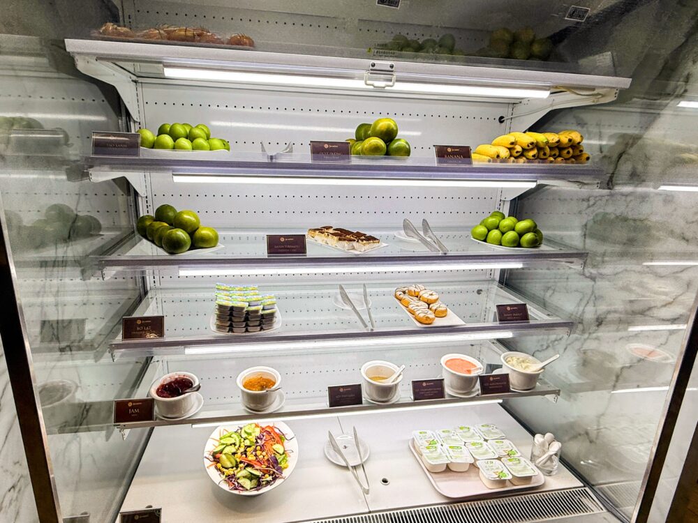 4段の冷蔵ショーケース。上段にはバナナや青りんごなどのフルーツ、中段には一口サイズのケーキやドーナツ、下段には小分けにされたサラダボウルやヨーグルト、ドレッシングが並んでいる。