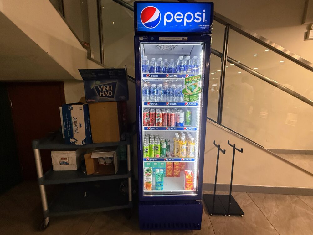 ペプシのロゴが入った縦型の冷蔵ショーケース。中にはペプシコーラ、セブンアップ、ミリンダなどの炭酸飲料や、ミネラルウォーター（Aquafina）、缶ジュース、紙パック飲料が大量に補充されている。