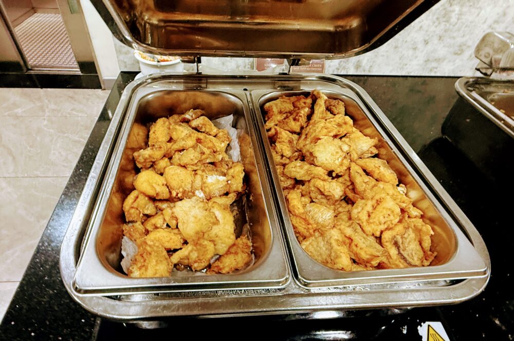 黄金色に揚げられた白身魚のフリッター（Deep-Fried Battered Fish）が大量に盛られている。衣はサクサクとした見た目。