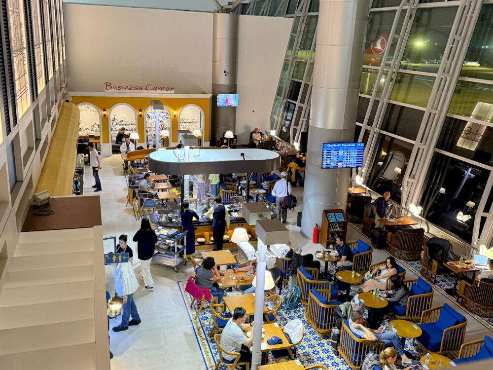 2階から見下ろしたロータスラウンジ2の全景。吹き抜け構造になっており、大きな窓の外には飛行機が見える。ビジネスセンターや食事エリアがある。
