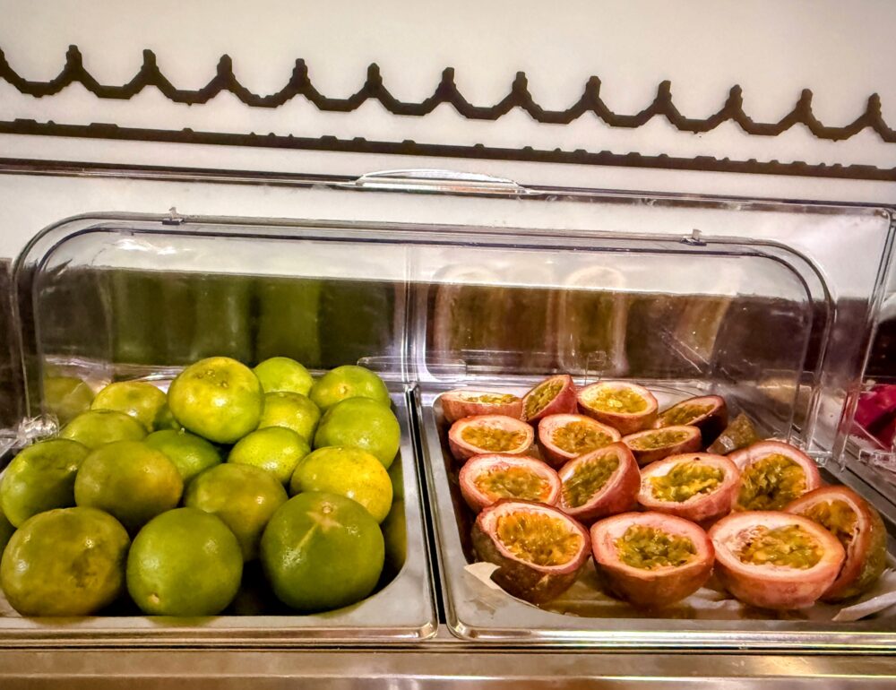 ビュッフェ台に並ぶパッションフルーツやグリーンオレンジなどの新鮮な果物。