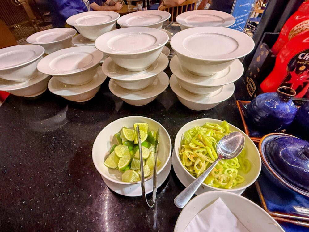 フォーのトッピング用薬味。カットされたライムと青唐辛子がボウルに盛られている。