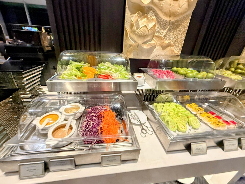 新鮮なレタスやキャベツ、ドレッシングが並ぶサラダバーコーナー。