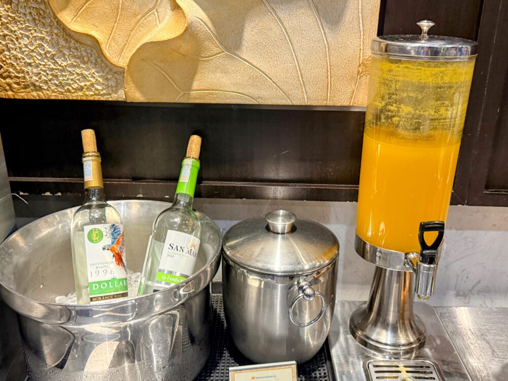 氷で冷やされた白ワインのボトルと、オレンジジュースのサーバー。