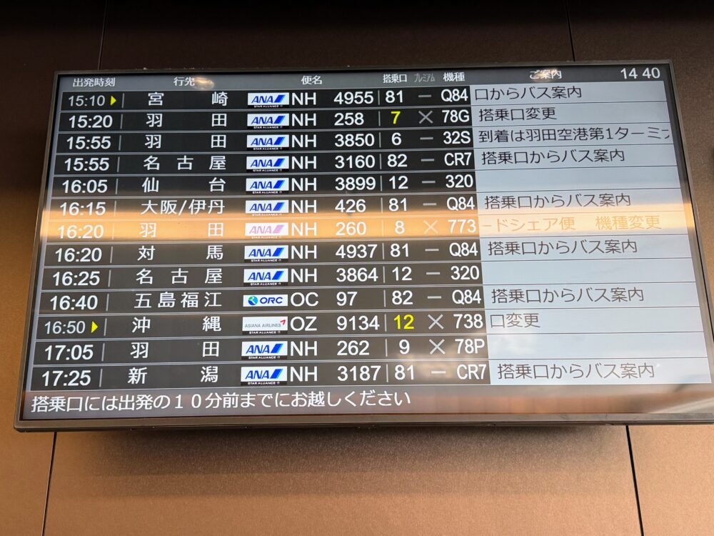 ラウンジ内に設置された出発便案内モニター（電光掲示板）。搭乗口や運行状況が表示されている。
