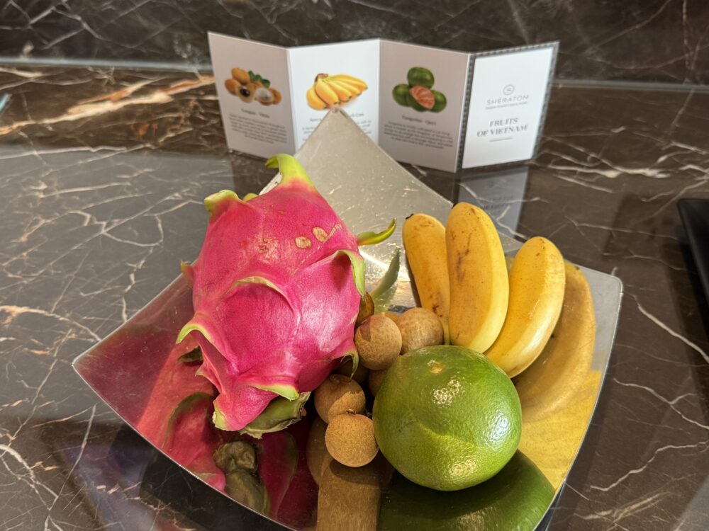 「FRUITS OF VIETNAM」のカードと共に盛られたドラゴンフルーツやバナナなどの豪華なウェルカムフルーツ。