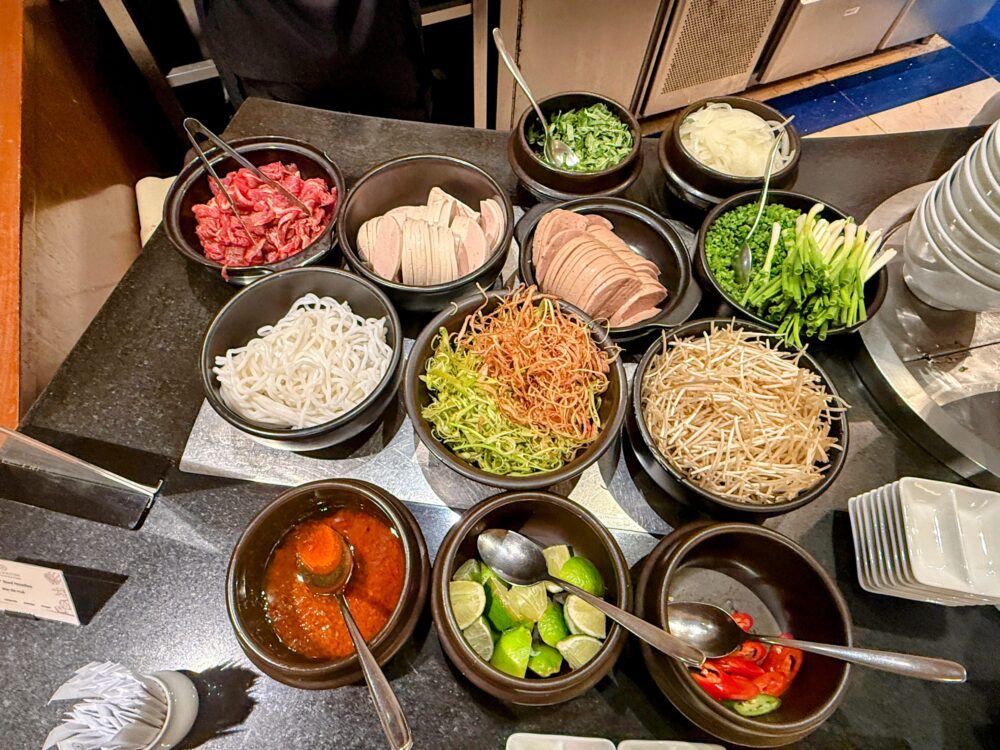 ラウンジのライブキッチンに用意されたフォーの麺(ブン)とたっぷりの牛肉、薬味のネギ。
