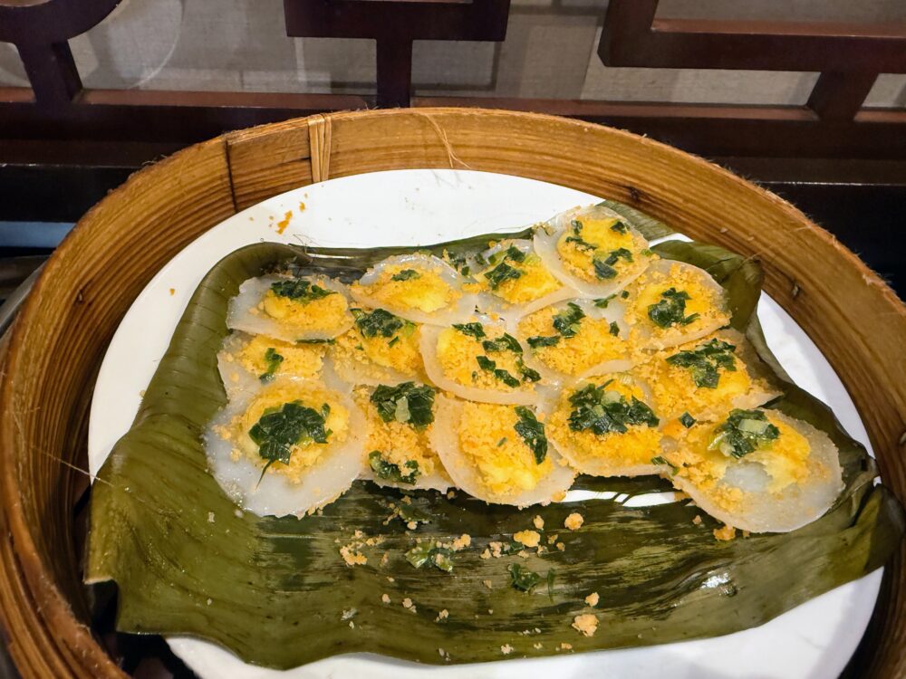 バナナの葉に乗せて蒸された、ベトナム風の米粉の蒸し餅(バイン・ベオのようなローカル料理)。