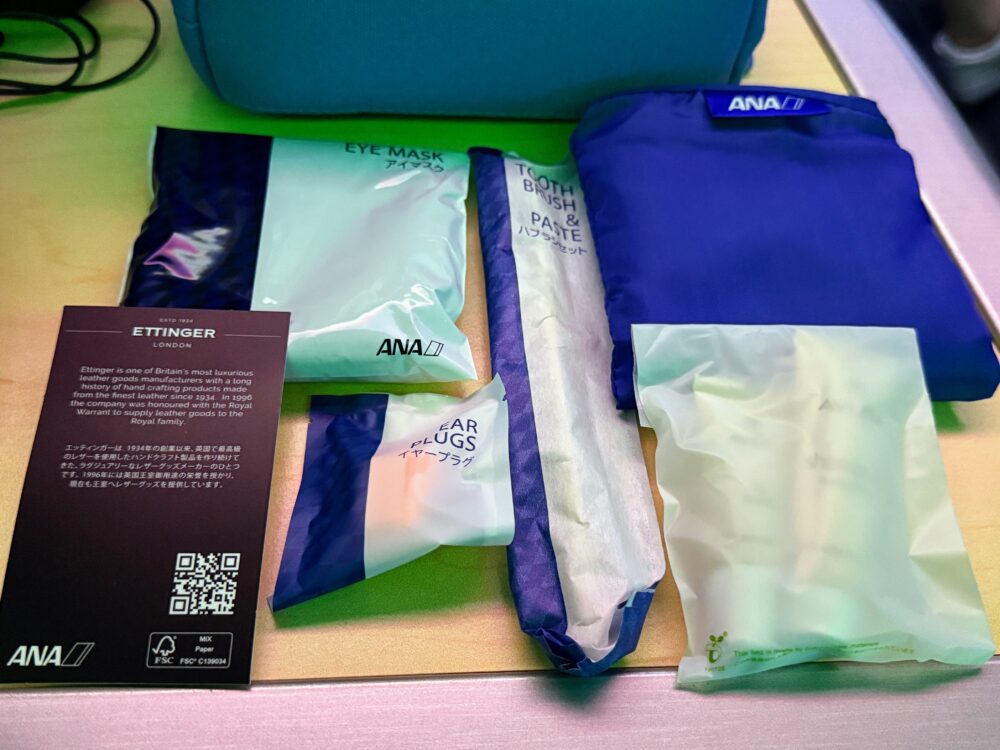 エッティンガーのポーチの中身。アイマスク、歯ブラシセット、耳栓、AVEDAのスキンケア用品などが含まれている。