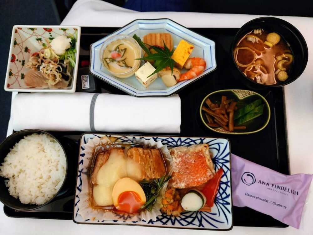 友人が選択したANAビジネスクラスの和食膳。主菜の魚料理に加え、繊細な盛り付けの小鉢や味噌汁が並ぶ。