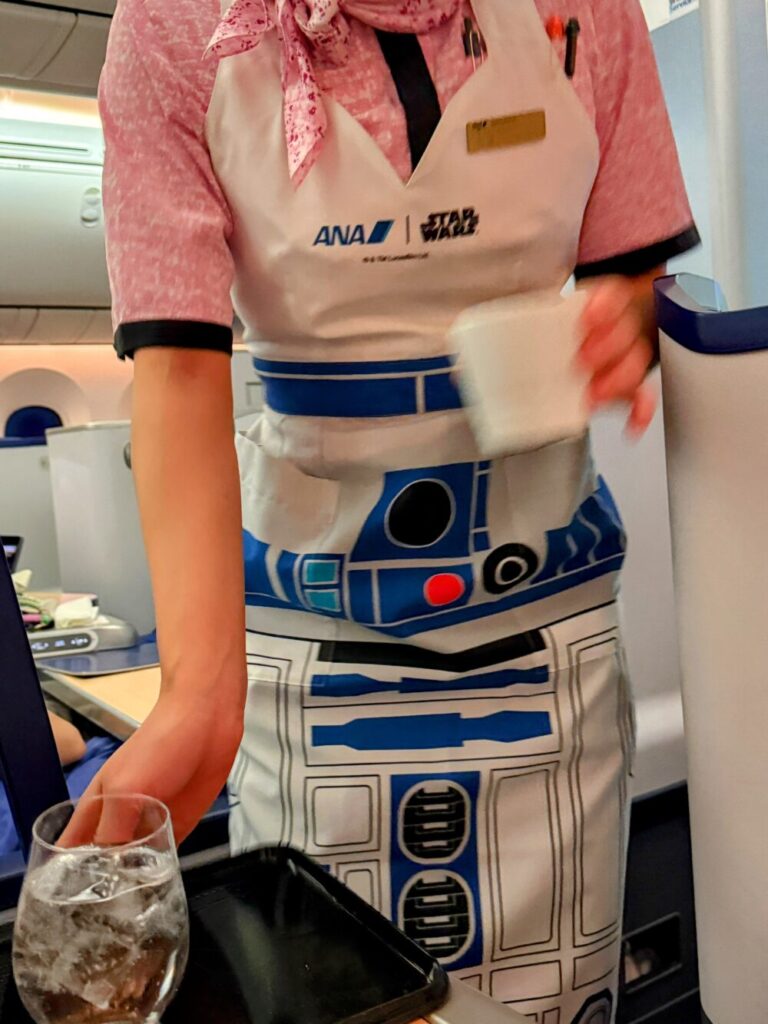 R2-D2のデザインが施された特別なエプロンを着用してサービスを行う客室乗務員。