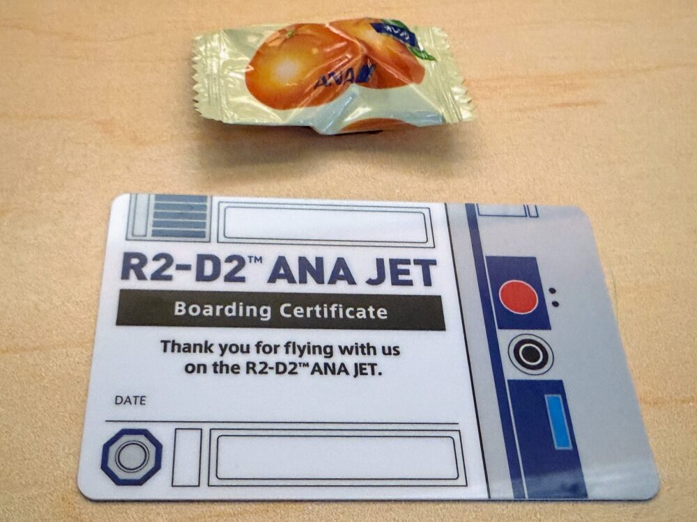 記念にいただいた「R2-D2 ANA JET」の搭乗証明書(Boarding Certificate)と機内サービスの飴。