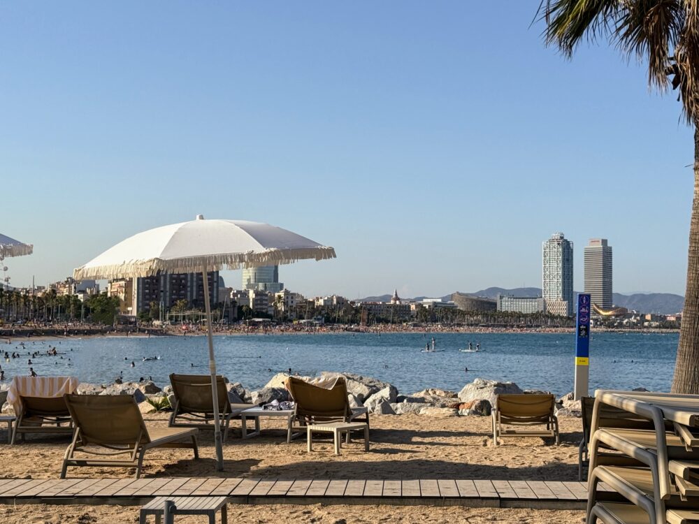 バルセロナのビーチ。砂浜にビーチパラソルとビーチチェアのある風景。