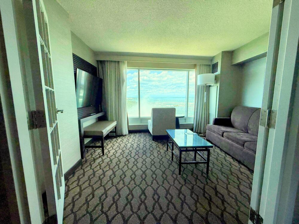 客室の窓際に設けられた広々としたサンルームのようなリビングスペースとソファ。窓の外には絶景が広がる。
