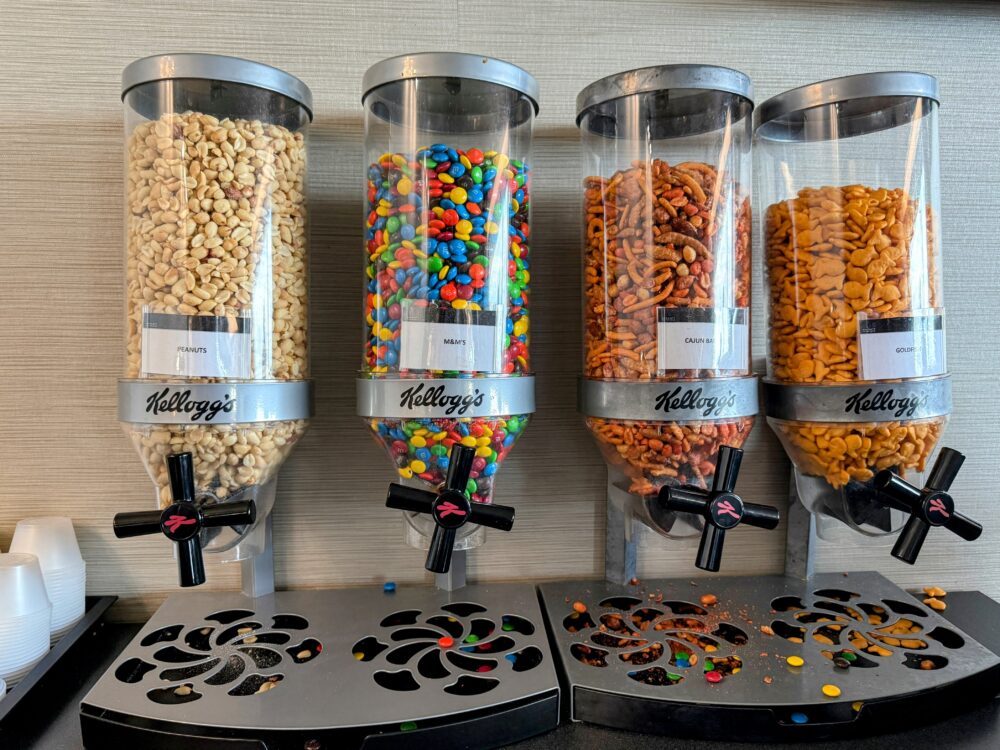 セルフサービスのスナックディスペンサー(ピーナッツ、M&M'sチョコ、スパイシーミックス、ゴールドフィッシュ)。
