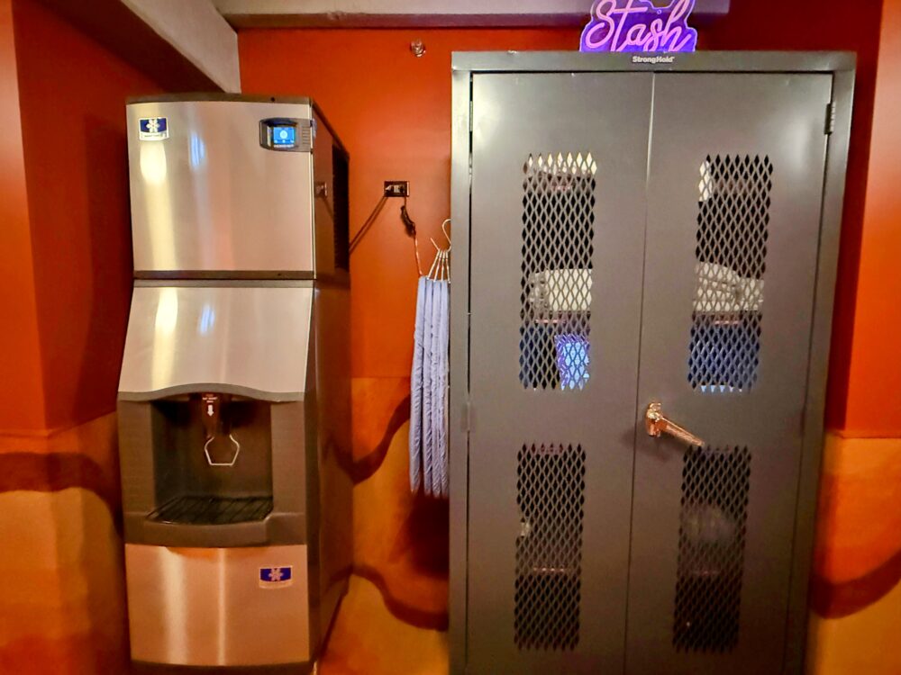 エレベーター近くにある「Stash」と書かれたネオンサインが光るアメニティ棚と製氷機。