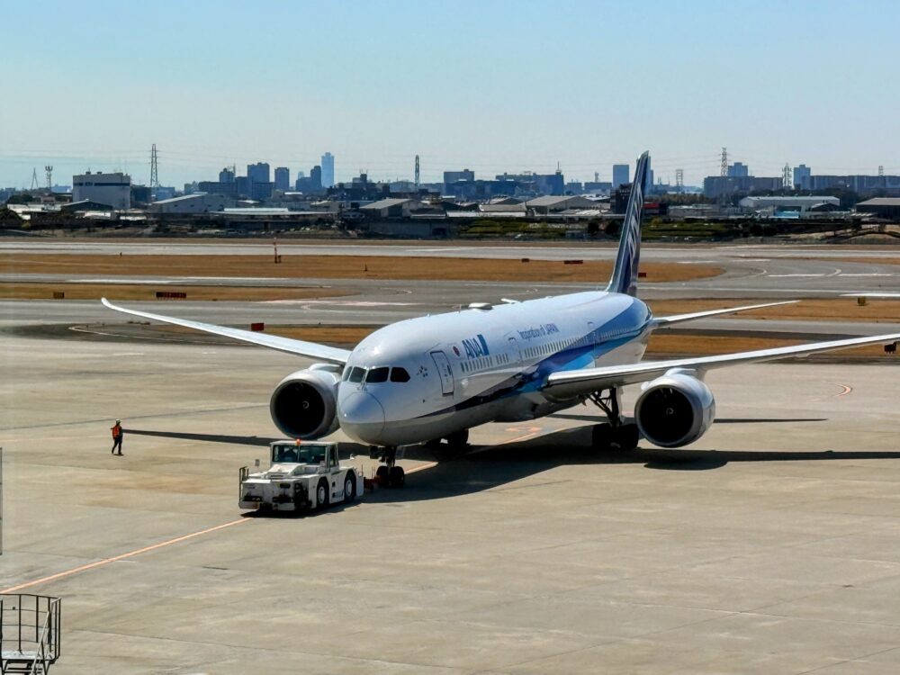 伊丹空港のANAスイートラウンジから間近に見える、トーイングカーに押されるANA機。