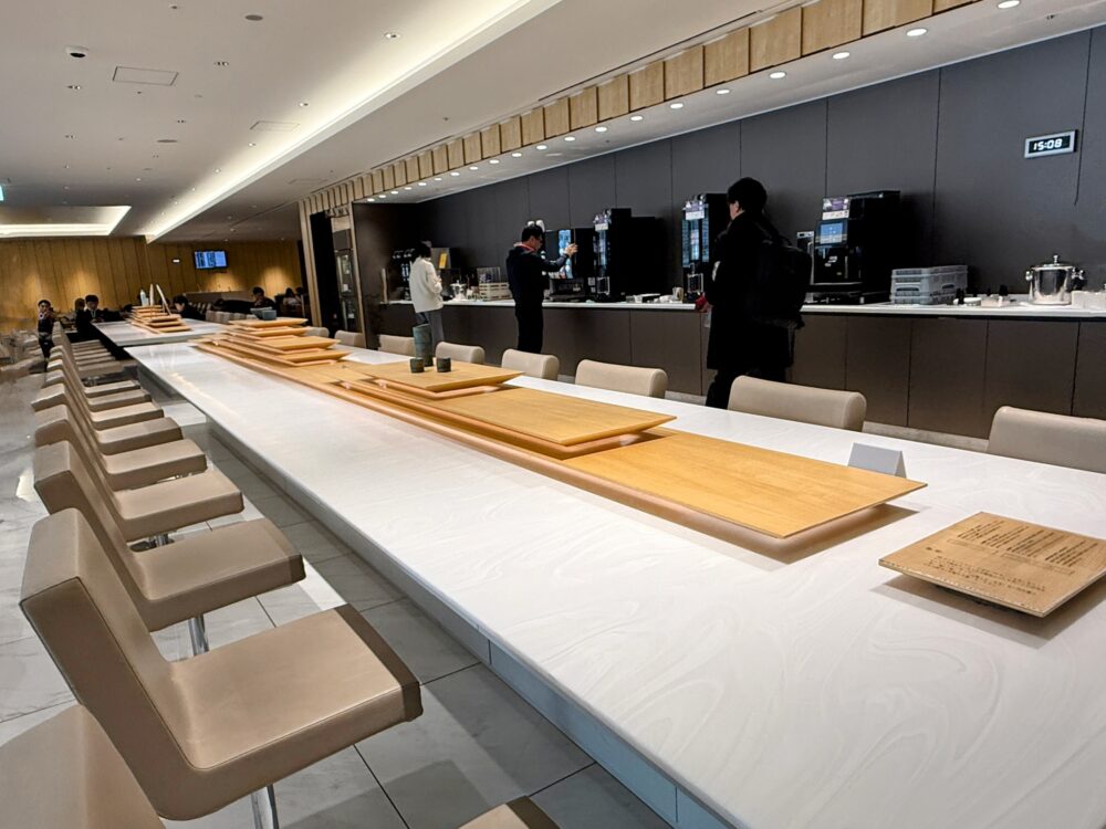 伊丹空港ANAラウンジ内の広々としたロングカウンターテーブルとドリンクコーナー。