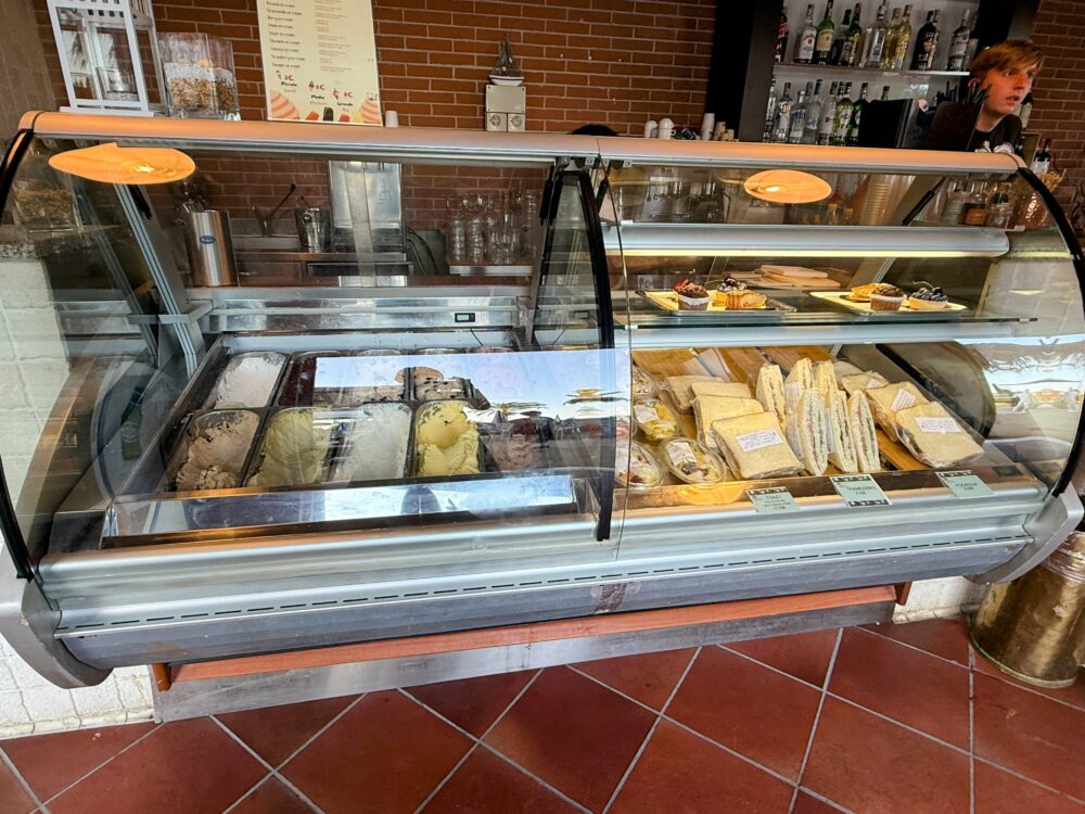 プールサイドの売店ショーケースに並ぶ、色とりどりのジェラートやサンドイッチ、ケーキ。