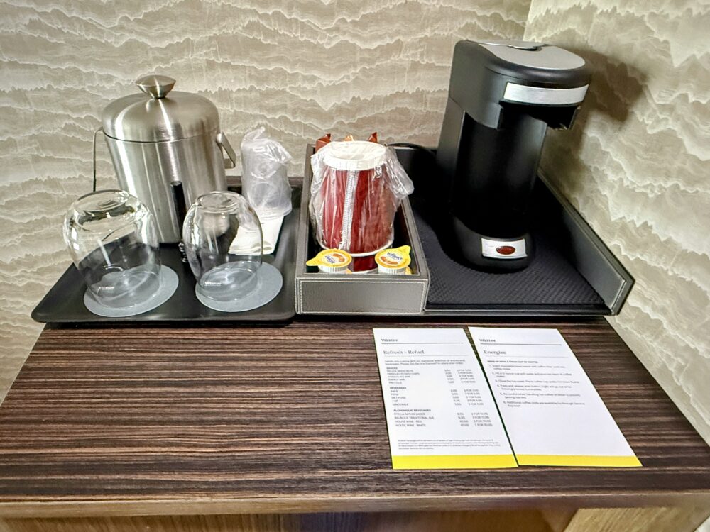 客室のミニバーコーナー。ステンレス製のアイスペール、グラス、コースター、コーヒーメーカーがトレーにセットされている。