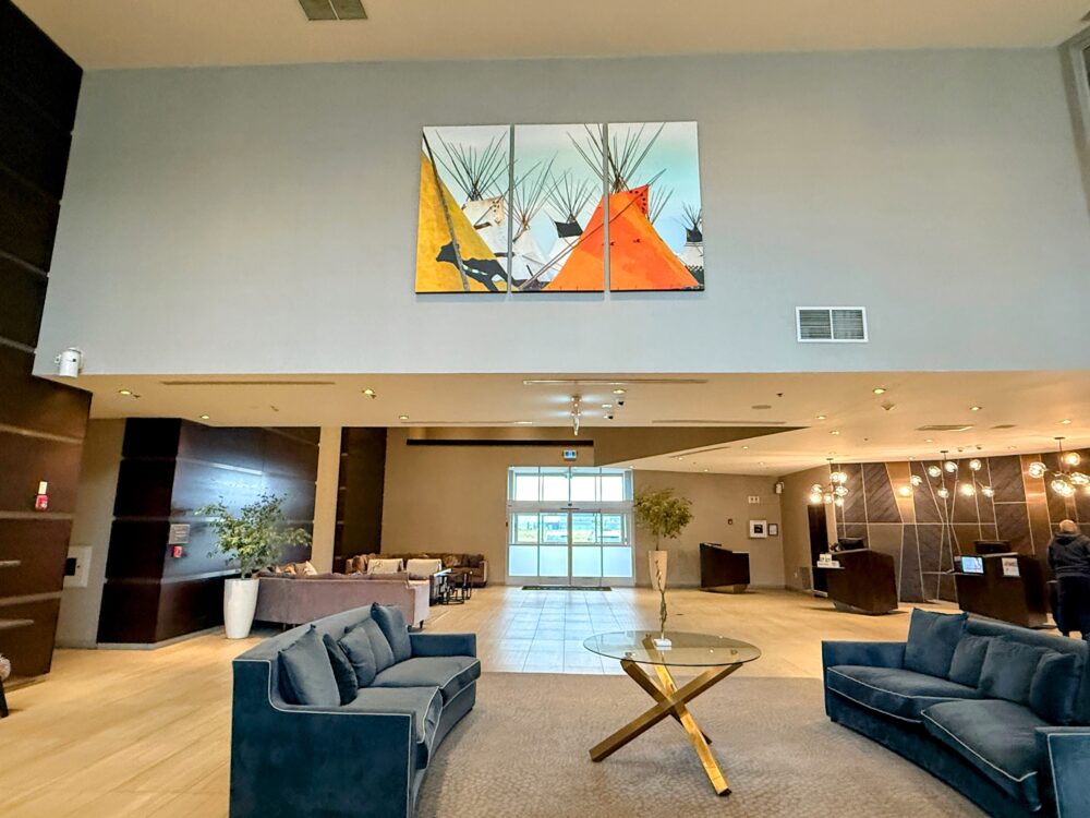 ロビーのシーティングエリア。鮮やかなティピー(テント)の絵画と、落ち着いたブルーのソファーセット。