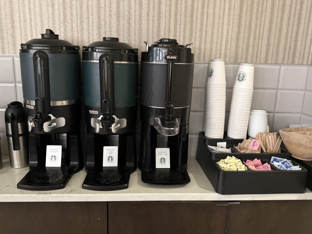 スターバックスのロゴが入ったコーヒーサーバー。ホットウォーター、カフェ、デカフェが並ぶ。
