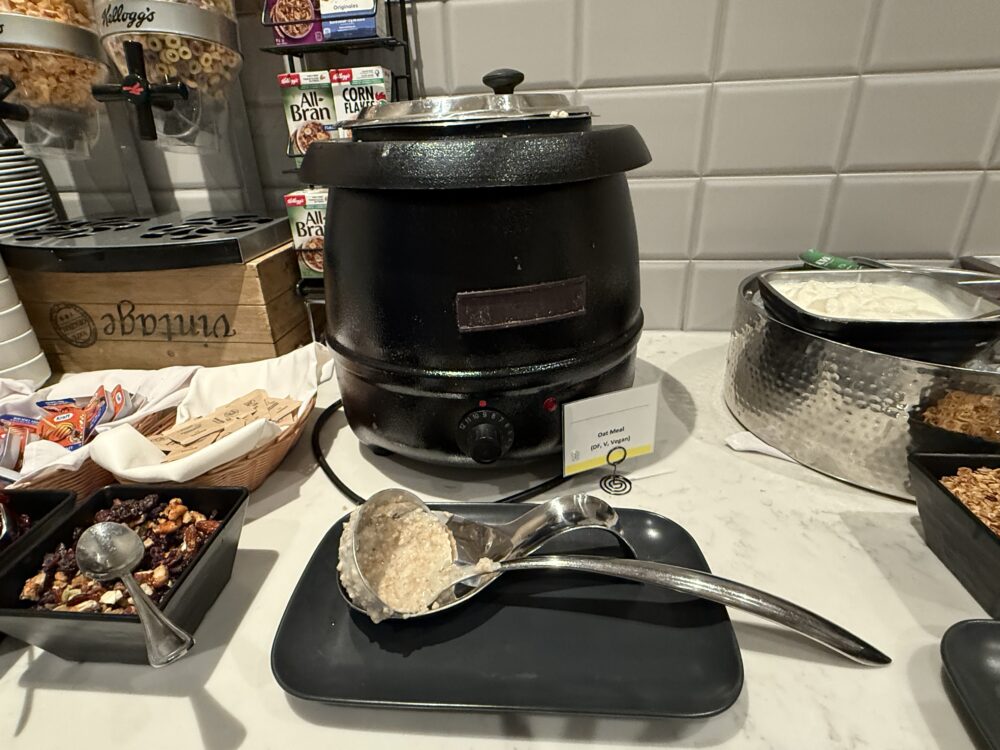 温かいオートミールが入った黒いスープジャー。「Oat Meal (DF, V, Vegan)」の表示がある。