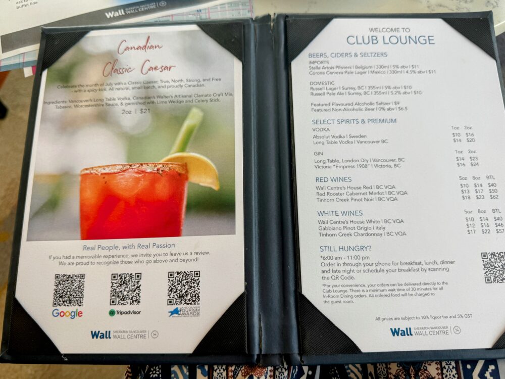 クラブラウンジのアルコールメニュー表。「Welcome to CLUB LOUNGE」の文字とともに、ビール、ワイン、スピリッツの価格($10〜)が記載されている。左ページには名物カクテル「Canadian Classic Caesar」の写真がある。