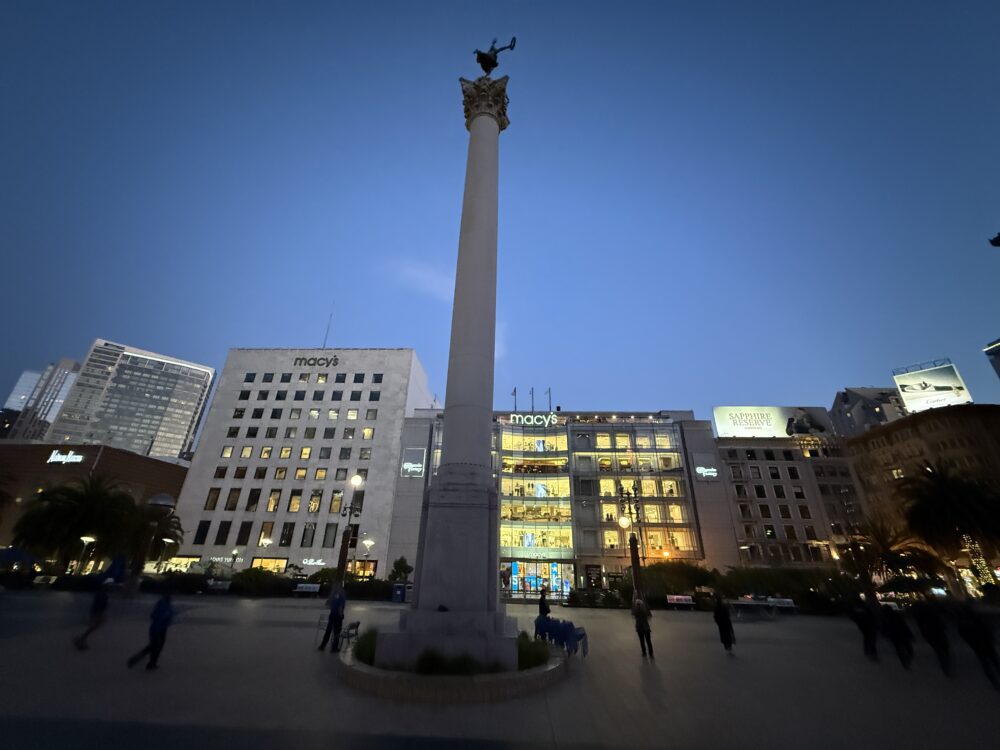 ホテルから徒歩すぐの場所にあるユニオンスクエア。夕暮れ時の広場にはデューイ記念塔がそびえ立ち、背景にはメイシーズ(Macy's)デパートの灯りが煌めく。