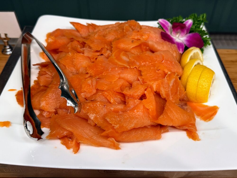 朝食ビュッフェのスモークサーモン。レモンが添えられた肉厚なサーモン。