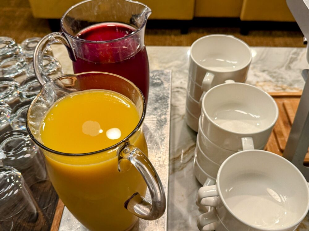 ピッチャーに入ったオレンジジュースとクランベリージュース。
