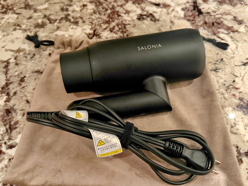 客室に備え付けられている「SALONIA(サロニア)」の黒いヘアドライヤーと専用ポーチ。