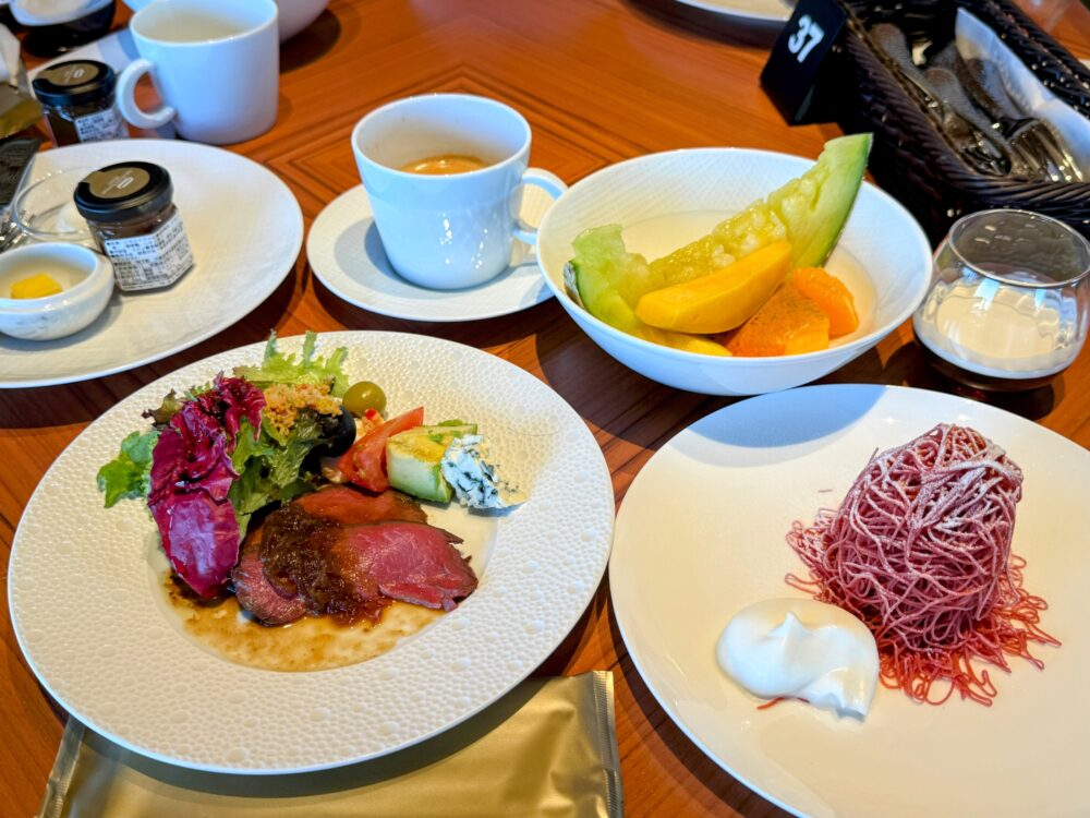 実際にお皿に取り分けた豪華な朝食。ローストビーフとサラダ、メロンなどのフルーツ盛り合わせ、ピンク色の生搾りモンブラン、そしてコーヒー。