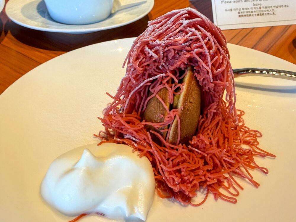 生搾りモンブランの断面。ピンク色のクリームの中に、カットされた「どら焼き」が丸ごと入っているユニークな一品。