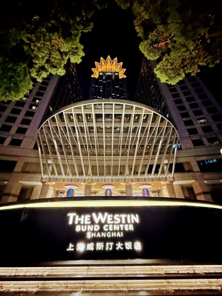 夜間ライトアップされたウェスティン外灘センター上海の外観エントランスと屋上の「黄金の蓮」。
