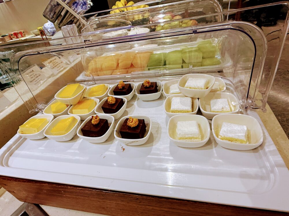 No.71ラウンジのデザートコーナー。マンゴープリン、チョコレートブラウニー、雪花糕(ミルクケーキ)が小皿に並び、奥にカットフルーツも用意されている。