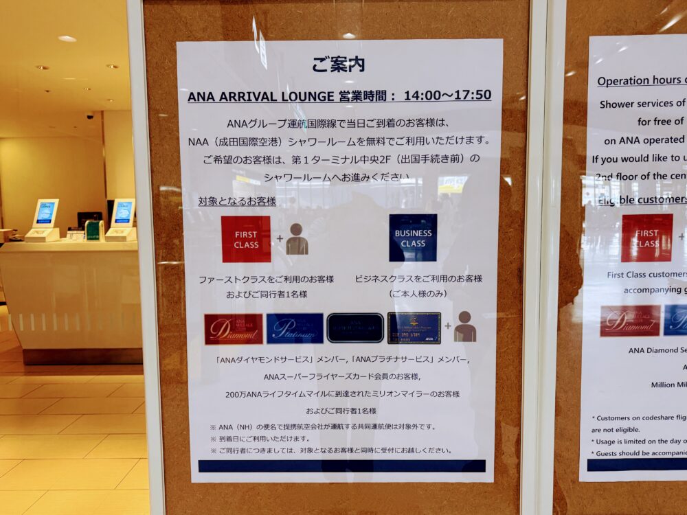 ANA ARRIVAL LOUNGE入口のガラスドアに貼られた案内掲示。「ANA ARRIVAL LOUNGE 営業時間:14:00〜17:50」と記載されており、ANAグループ運航国際線で当日到着の旅客はNAA(成田国際空港)シャワールームを無料で利用できる旨が案内されている。対象者としてファーストクラス(同行者1名可)、ビジネスクラス(本人のみ)、ダイヤモンド・プラチナ・スーパーフライヤーズ・ミリオンマイラーの各メンバーが図入りで示されている。