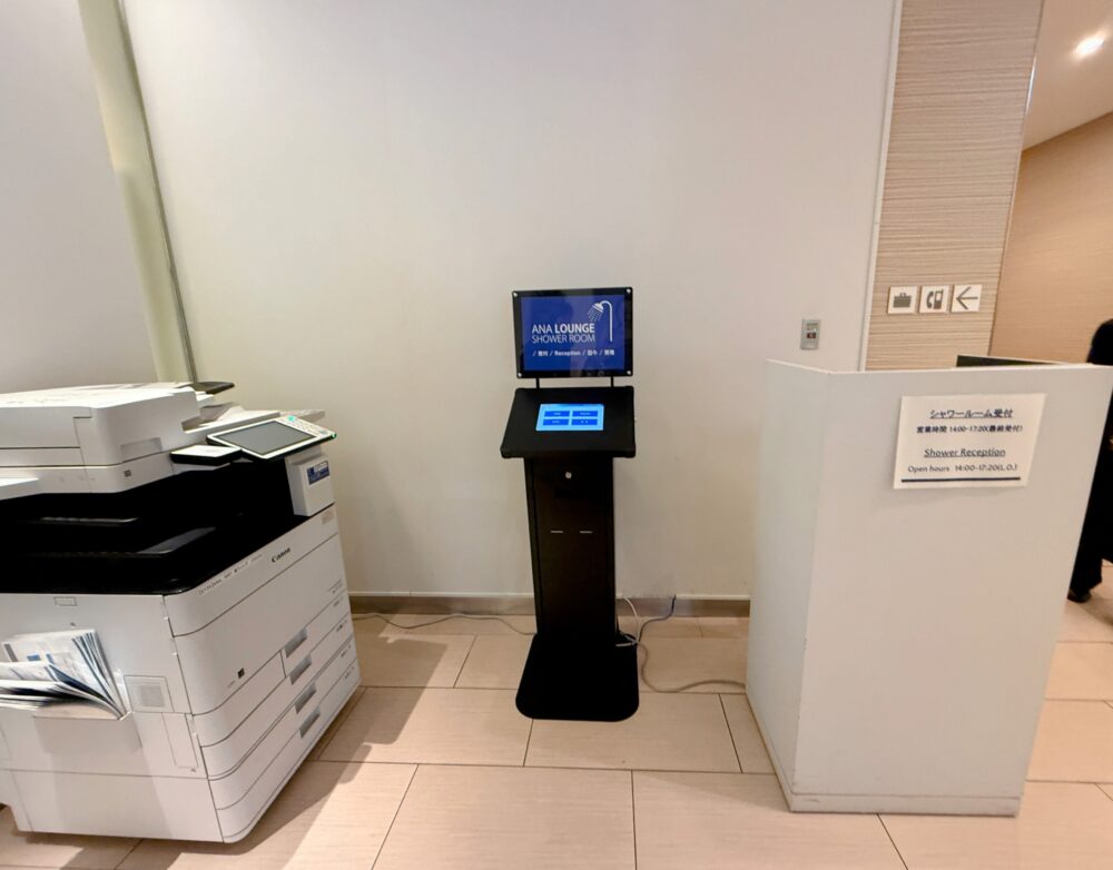 このラウンジを利用して特によかったと感じたのが、シャワーが予約なしですぐに使えたことです。
画像を表示
シャワールームは、ラウンジ内に受付カウンターが設けられています。タッチパネル式の端末で手続きができ、待ち時間なくすぐに案内してもらえました。営業時間は14:00〜17:20(最終受付)と、ラウンジ本体よりも少し早く締まる点は覚えておきたいポイントです。
長時間のフライトのあとにシャワーを使える環境があるのは、本当にありがたいものです。国際線到着後の疲れた体に、シャワーは格別でした。
アメニティの充実度が高い
画像を表示
入口付近の共用スペースには、シェービングジェル付きのSchickカミソリ、歯ブラシ、ヘアブラシ、シャワーキャップが用意されており、自由に持ち出せるようになっています。
シャワールーム内のかごには、スリッパ(持ち帰り可)、歯ブラシ、ヘアブラシ、アメニティセット、バスタオルがまとめて用意されていました。
ギャラリー:シャワールーム内のアメニティ一式 画像を表示
画像を表示
画像を表示
画像を表示 ドライヤーはPanasonic製が用意されており、洗面台まわりにはコーセーの雪肌精シリーズ(洗顔フォーム・化粧水・乳液)がたっぷりと置かれていました。
画像を表示
シャワー後のスキンケアまで充実しているのは、さすがANAラウンジといったところです。
シャワーブースはオーバーヘッドシャワー付き
ギャラリー:シャワーブース 画像を表示
画像を表示
画像を表示
画像を表示 シャワーブースには大きなオーバーヘッドシャワーとハンドシャワーの両方が備わっており、使い勝手は申し分ありません。タイルのデザインもおしゃれで、清潔感があります。
シャンプー・コンディショナー・ボディソープはいずれもPOLAのESTHE ROYERシリーズ。ホテルの高級ラインに引けを取らないクオリティで、フライト後の疲れた髪と肌を丁寧にケアできます。 続いて代替テキストです。 IMG_0476.JPG シャワールームの受付エリア。中央にタッチパネル式の「ANA LOUNGE SHOWER ROOM」と表示された案内端末が置かれ、右側に「シャワールーム受付 営業時間14:00-17:20(最終受付)」と記載された白いカウンターが設置されている。左にはコピー機も見える。