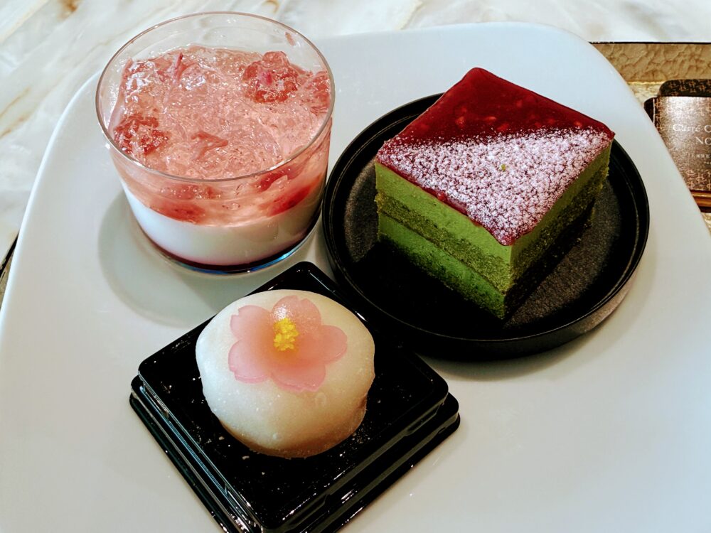 季節のデザートコーナー。抹茶ムースケーキ、桜のパンナコッタ、春桜（白餡・求肥）が並ぶ、目にも美しいラインナップ。