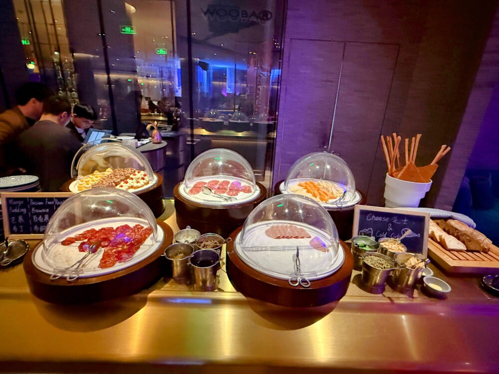 乾燥を防ぐ透明なドームカバーに入れられた、生ハムなどのコールドミートやチーズの盛り合わせ。