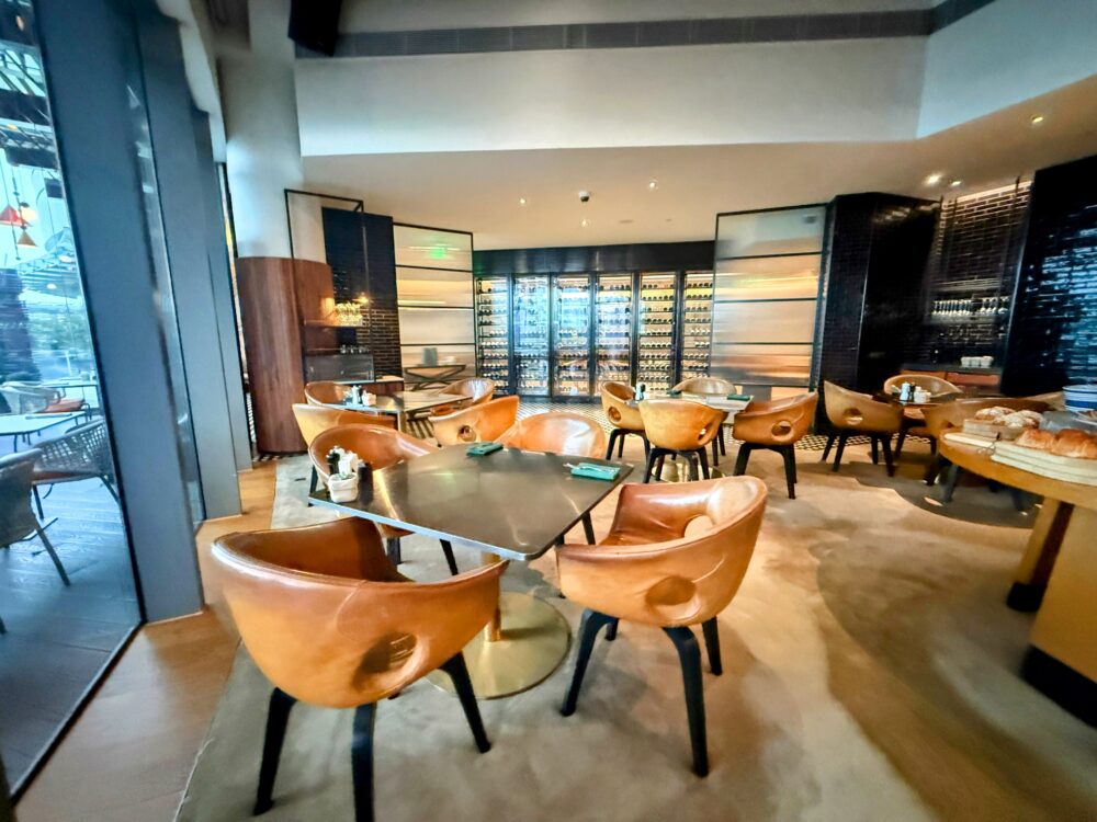 W上海の朝食会場。革張りの丸いチェアやワインセラーが並ぶ、スタイリッシュで広々とした屋内席。