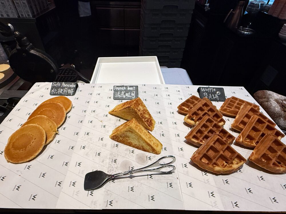 W上海の朝食ビュッフェで提供される、焼きたてのパンケーキ、フレンチトースト、ワッフルの盛り合わせ。