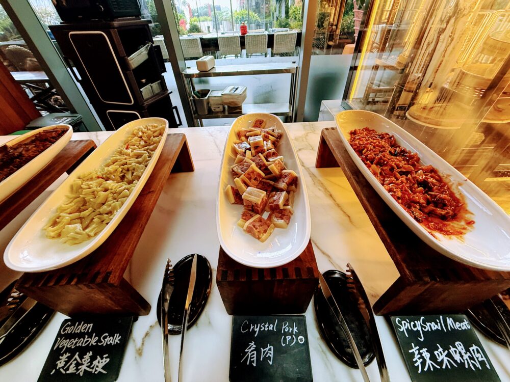 黄金野菜の茎や、ピリ辛の巻貝肉(Spicy Snail Meat)などの中華惣菜。