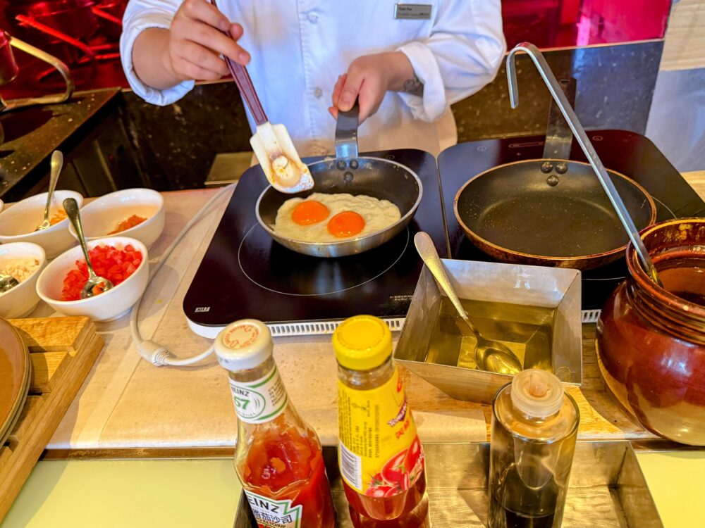 目玉焼きを焼くシェフの手元。