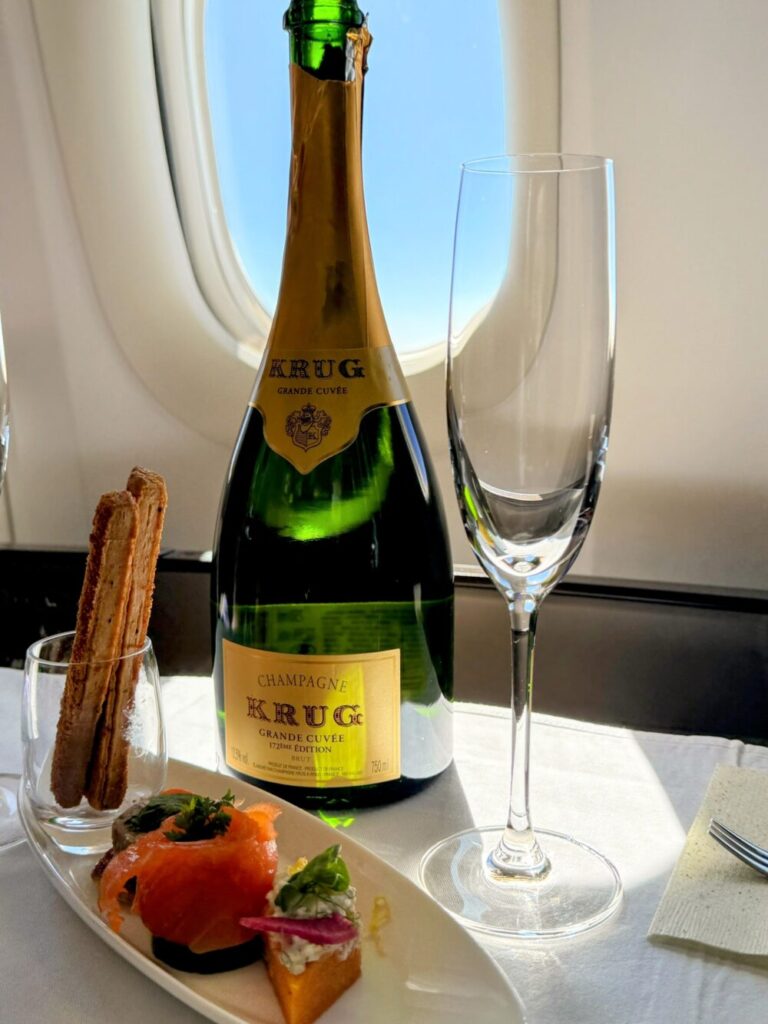 ANAファーストクラスで提供される最高級シャンパン「KRUG(クリュッグ)」のボトルと彩り豊かなアミューズ。