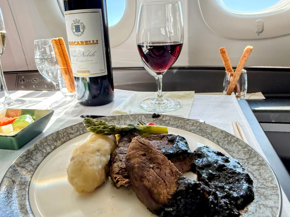 牛フィレ肉のステーキと、相性抜群の重厚なイタリア産赤ワインのボトルとグラス。