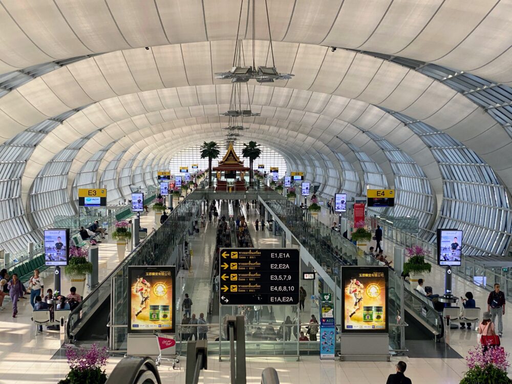バンコクの玄関口スワンナプーム空港のターミナル内。波打つ曲線の天井とタイ様式の祠が印象的な出発コンコース。